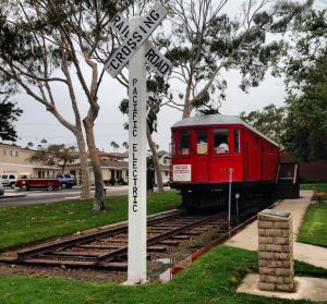 A restored vintage Pacific Electric Red Car on tracks in Seal Beach