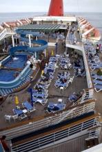 Carnival Paradise Cruise - Pool area - from Wikipedia by Beau Hudspeth