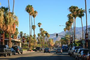 Street view of Downtown Palm Springs with palm trees and mountains