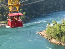 Red antique cable car suspended over the Niagara Whirlpool